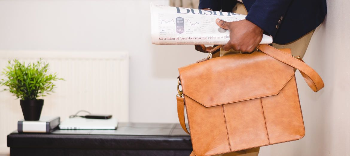 man holding briefcase and newspaper
